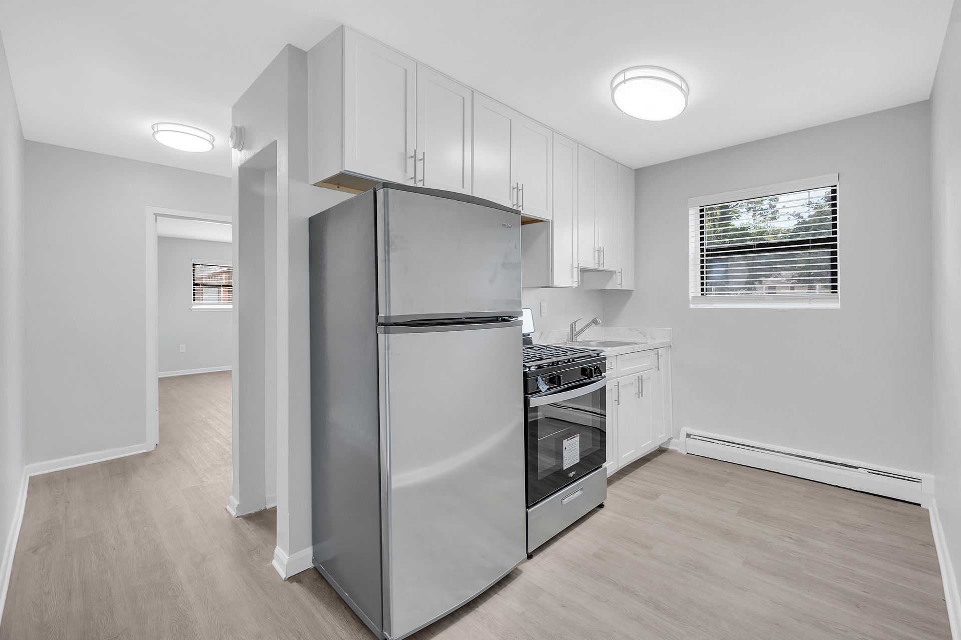 A kitchen with stainless steel appliances and white cabinets.