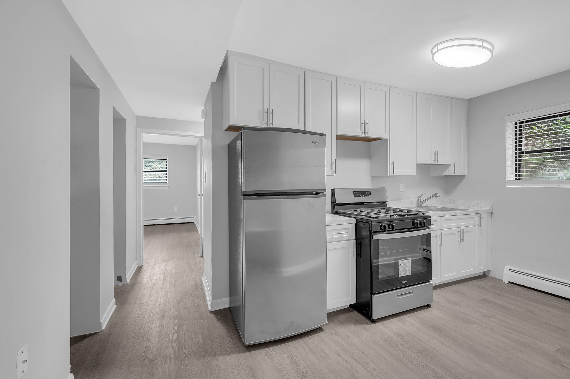 A kitchen with stainless steel appliances and white cabinets.