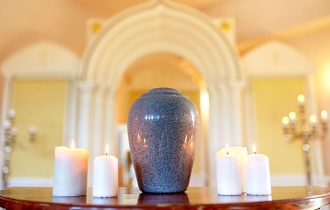 Blue urn with candles on a table in a softly lit arched hallway