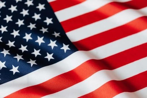 American flag waving with red and white stripes and white stars on a blue field