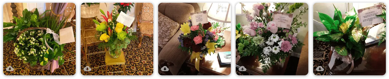 Five floral bouquets in baskets and vases on a wooden table and floor.