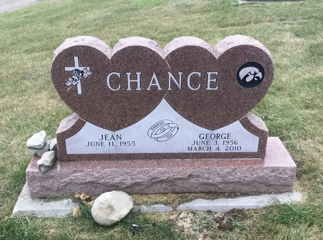 Heart-shaped gravestone engraved “Chance” on a pink granite base in a grassy cemetery.