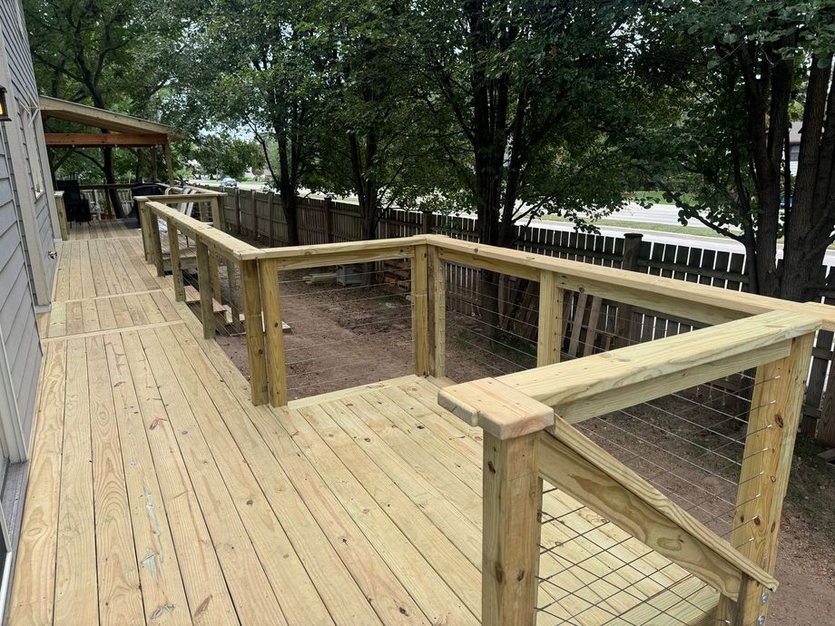 Wooden deck ramp with railings in a wooded outdoor area