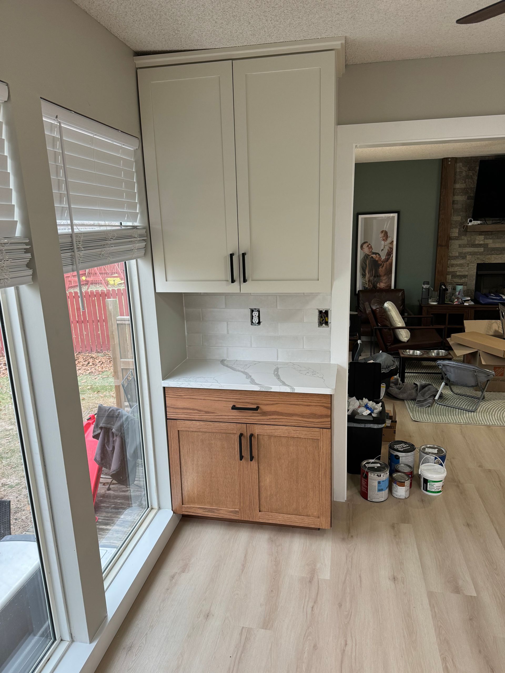 Kitchen nook with white cabinets, wood lower cabinet, and a glass door to a patio.