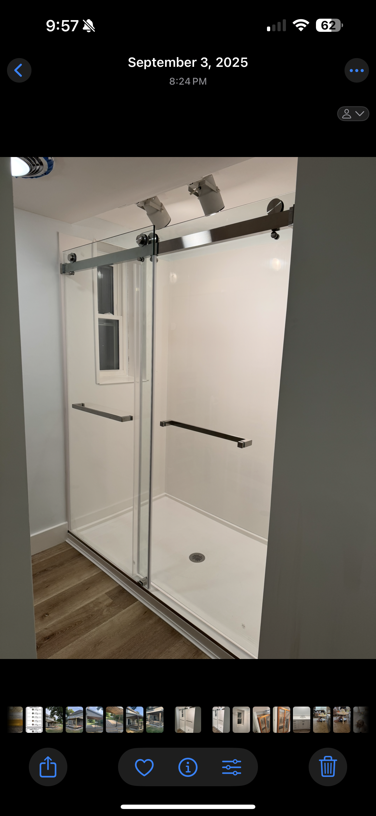 White mirrored closet doors with black hardware in a room, shown on a phone screen.