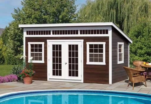 Brown garden shed with white trim beside a pool, surrounded by patio furniture and greenery