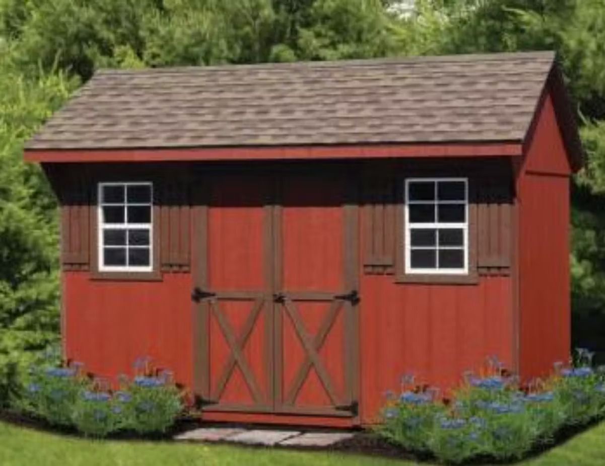 Red garden shed with white-trim windows, double doors, and flowers around the base.