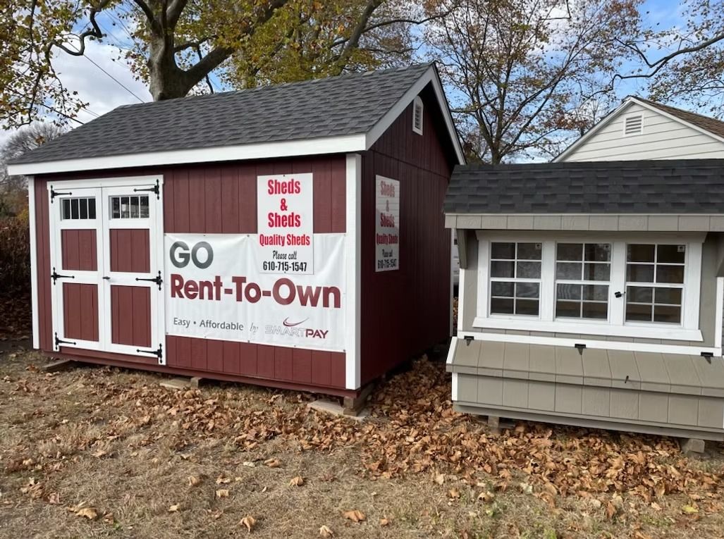 Small red and white rent-to-own office buildings with a “GO Rent-To-Own” sign in front of trees and leaves