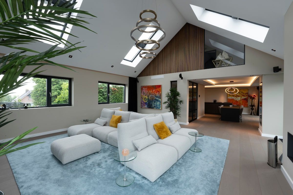 Een woonkamer met een witte bank en een blauw kleed