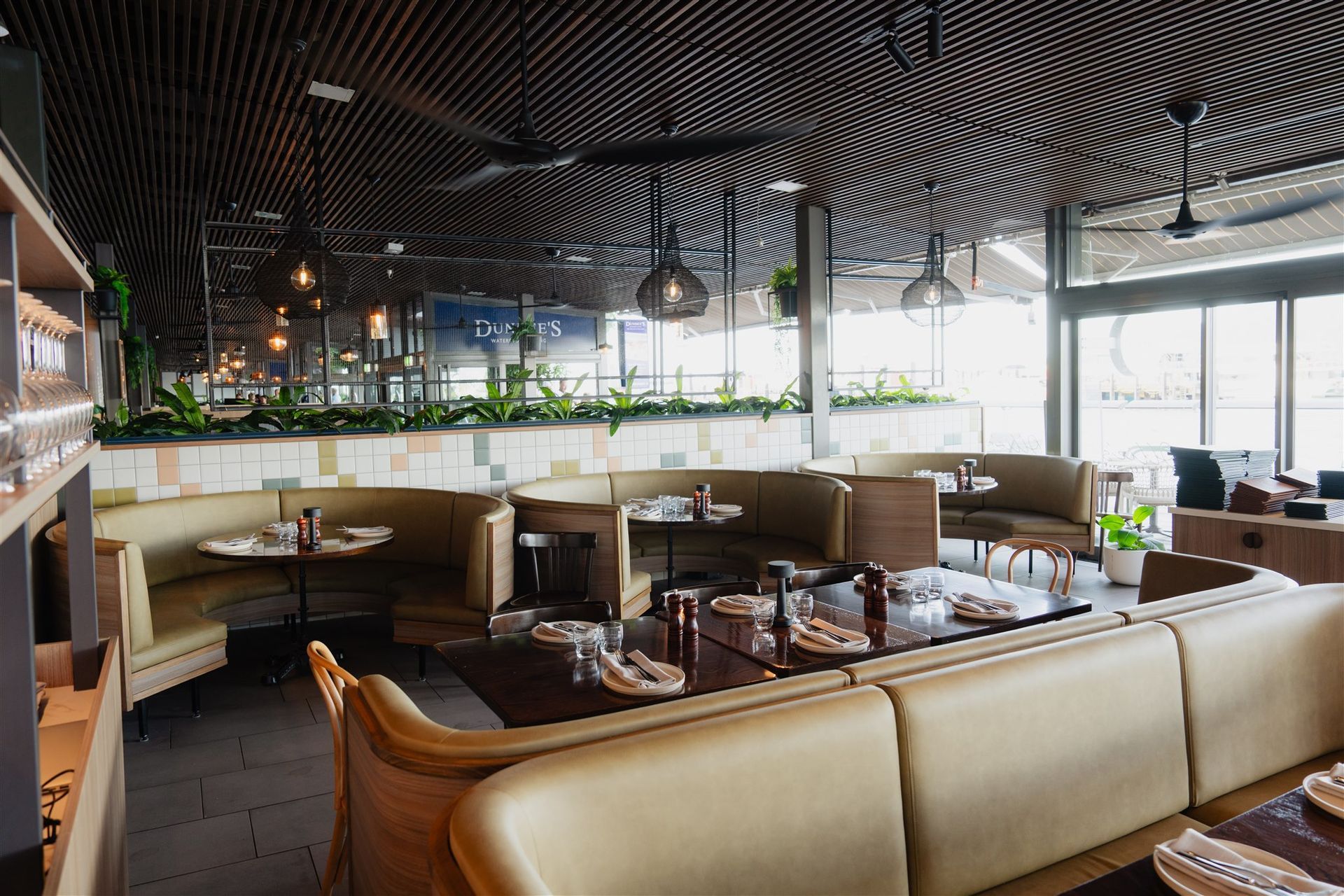 Wide view through the dining space highlighting seating layout, ceiling detail and natural light