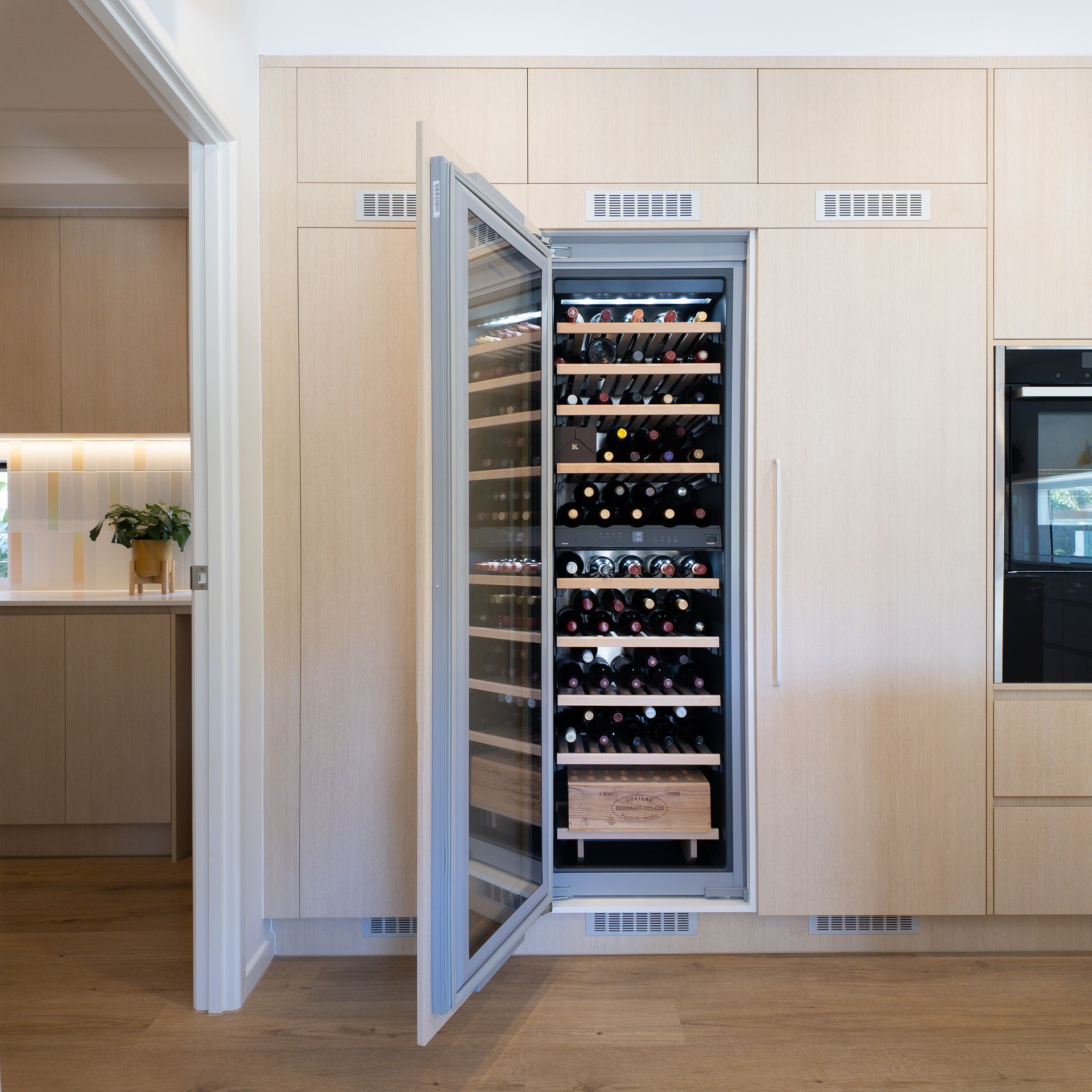Built-in wine fridge and custom storage integrated into kitchen joinery