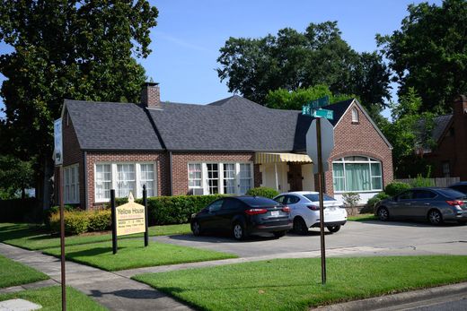 A brick house with cars parked in front of it
