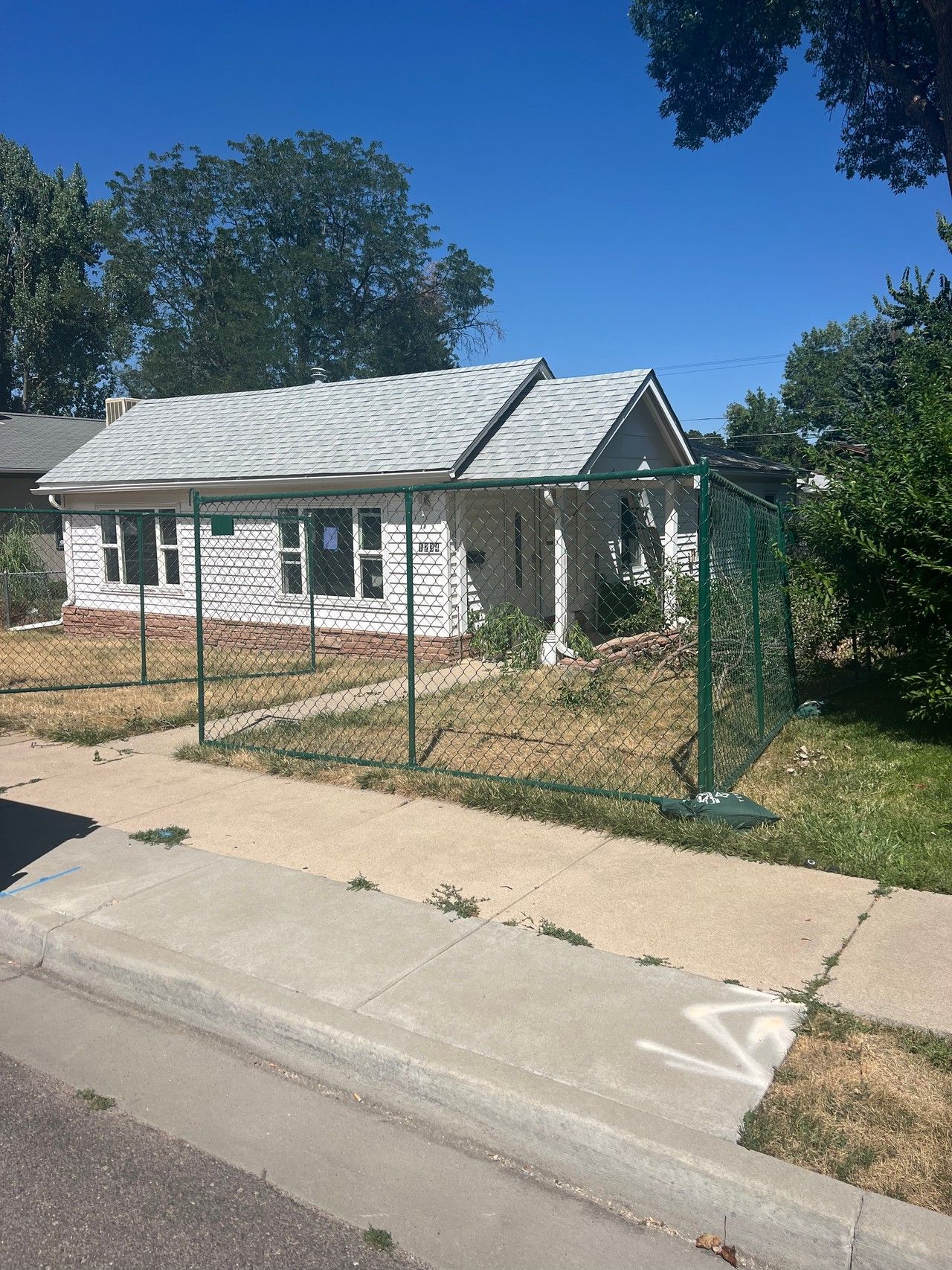 Original house and fenced front yard at 1234 Jefferson Avenue before demolition