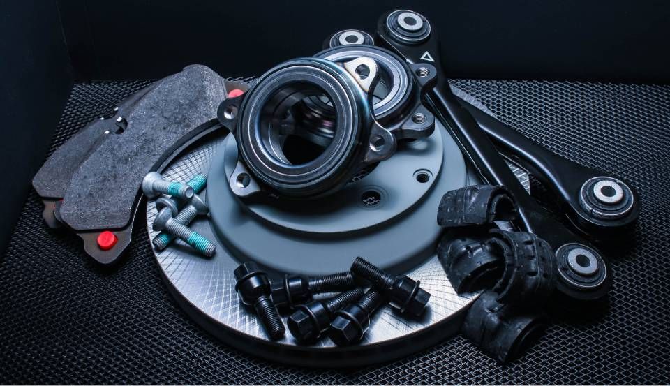 Camera lens and accessories arranged on a dark surface, including a central lens and small gadgets.