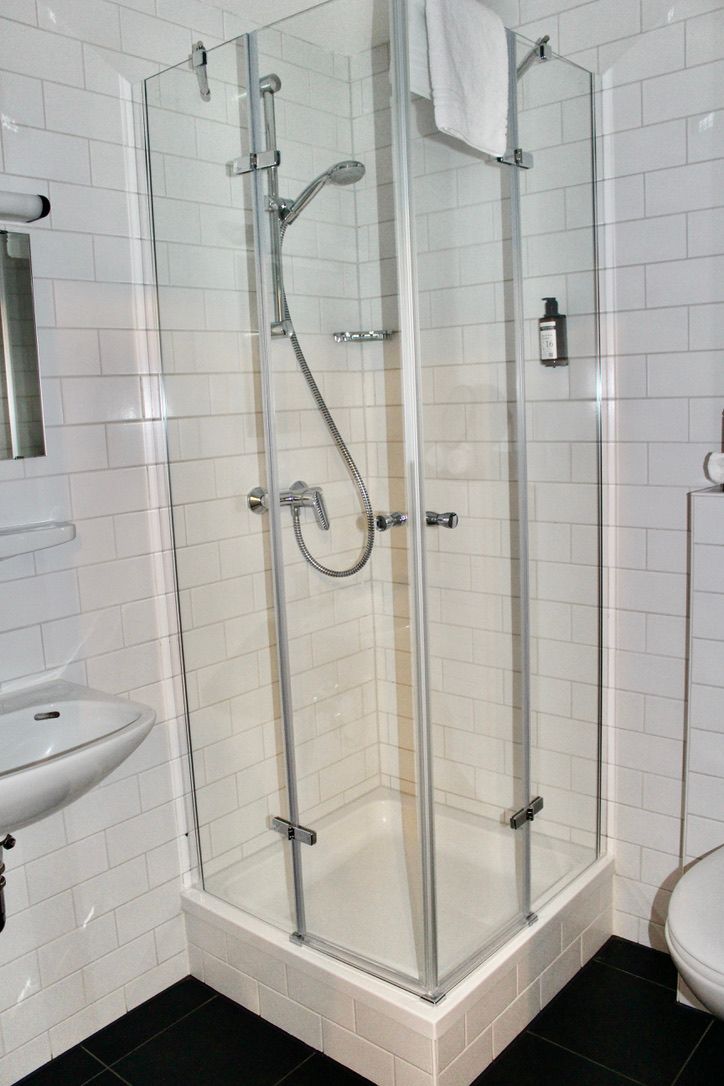 A bathroom with a toilet , sink and shower stall