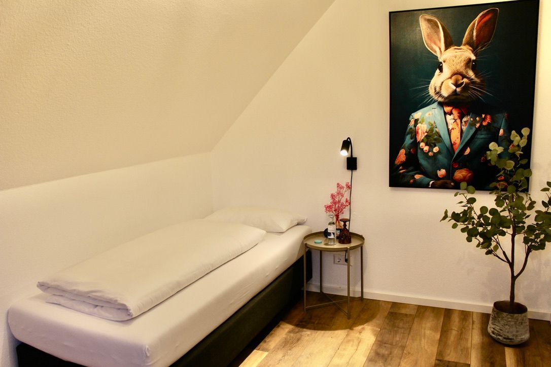 Triple Room with a painting of a rabbit on the wall above the bed.