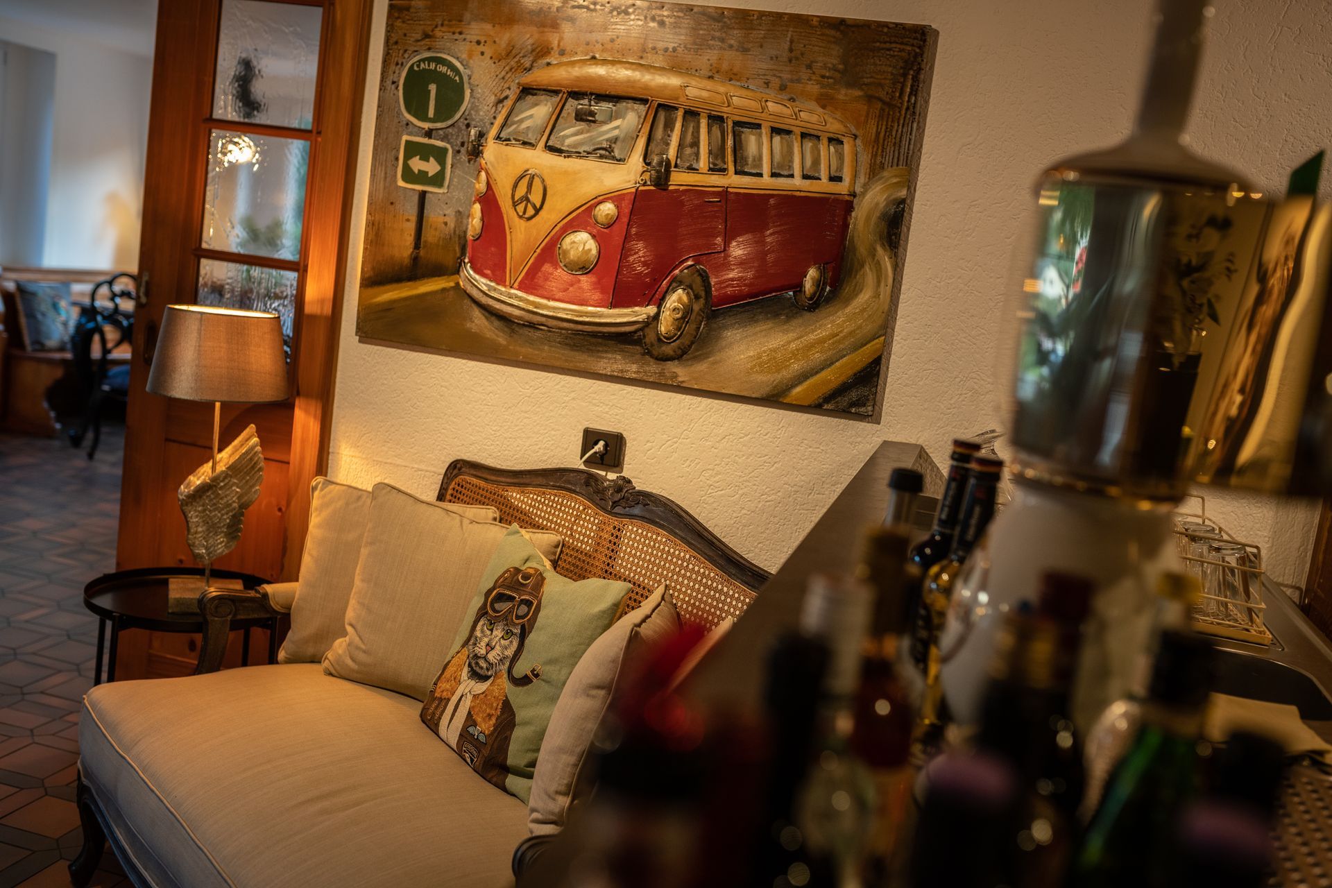 A living room with a couch and a painting of a bus on the wall.