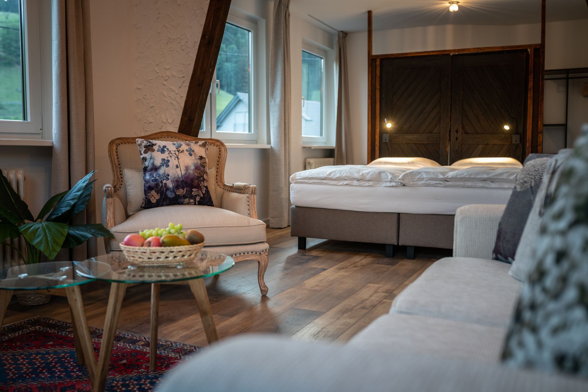 A living room with a couch , chair , table and bed.