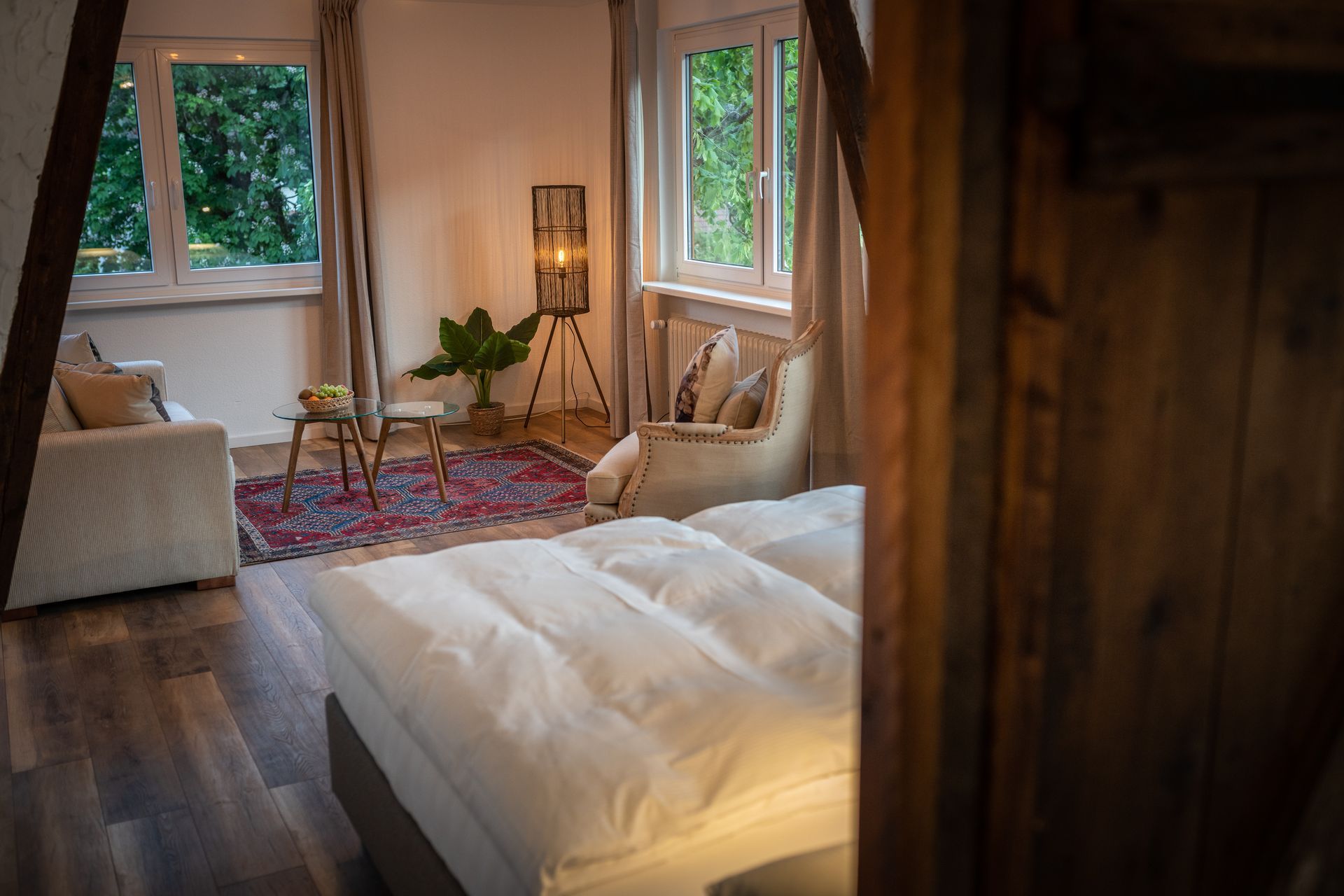 A bedroom with a bed , couch , chair and window.