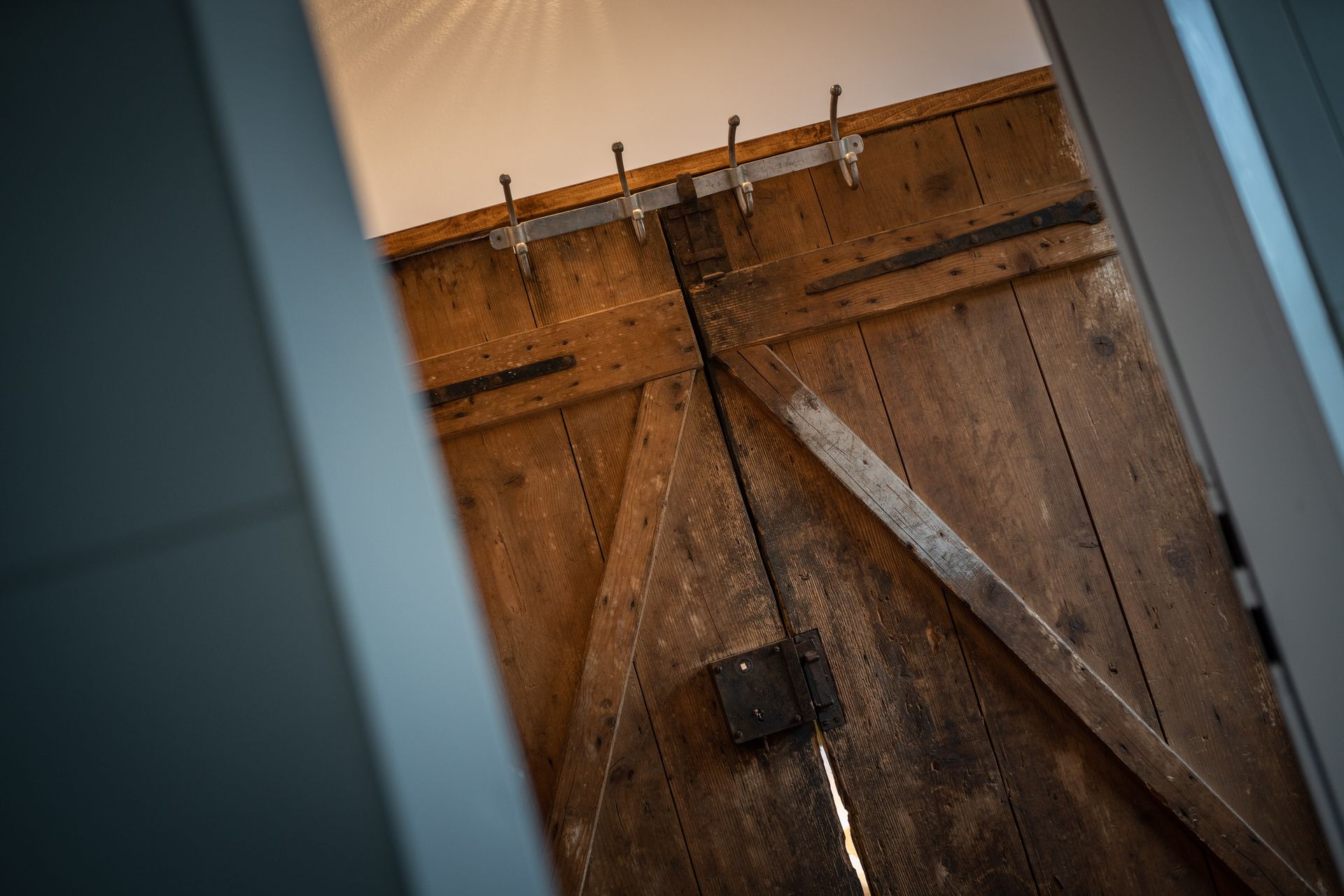 A close up of a wooden door with hooks on it.