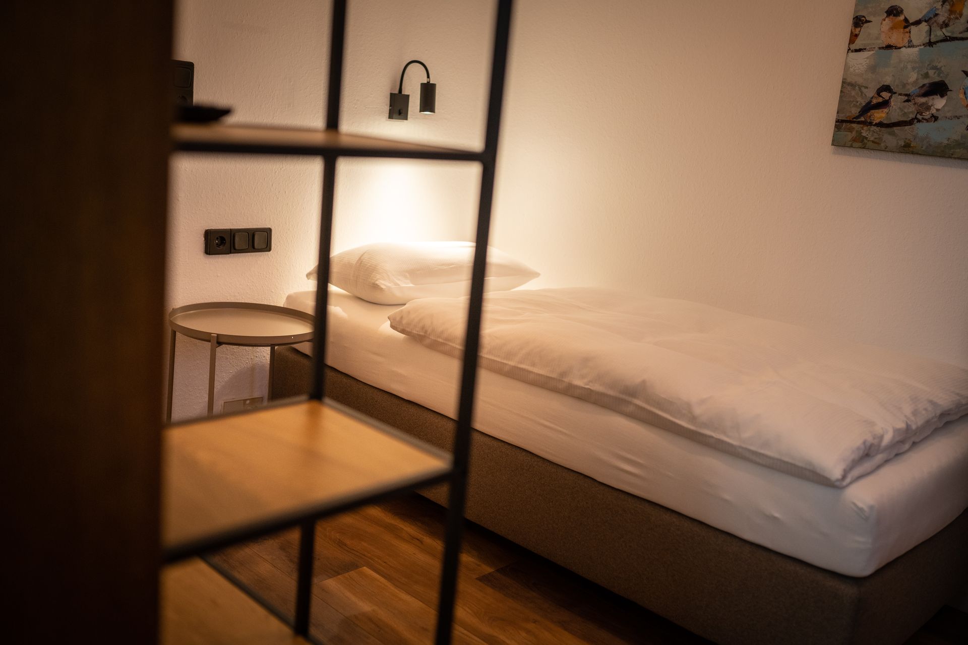 A bedroom with a single bed and a ladder.