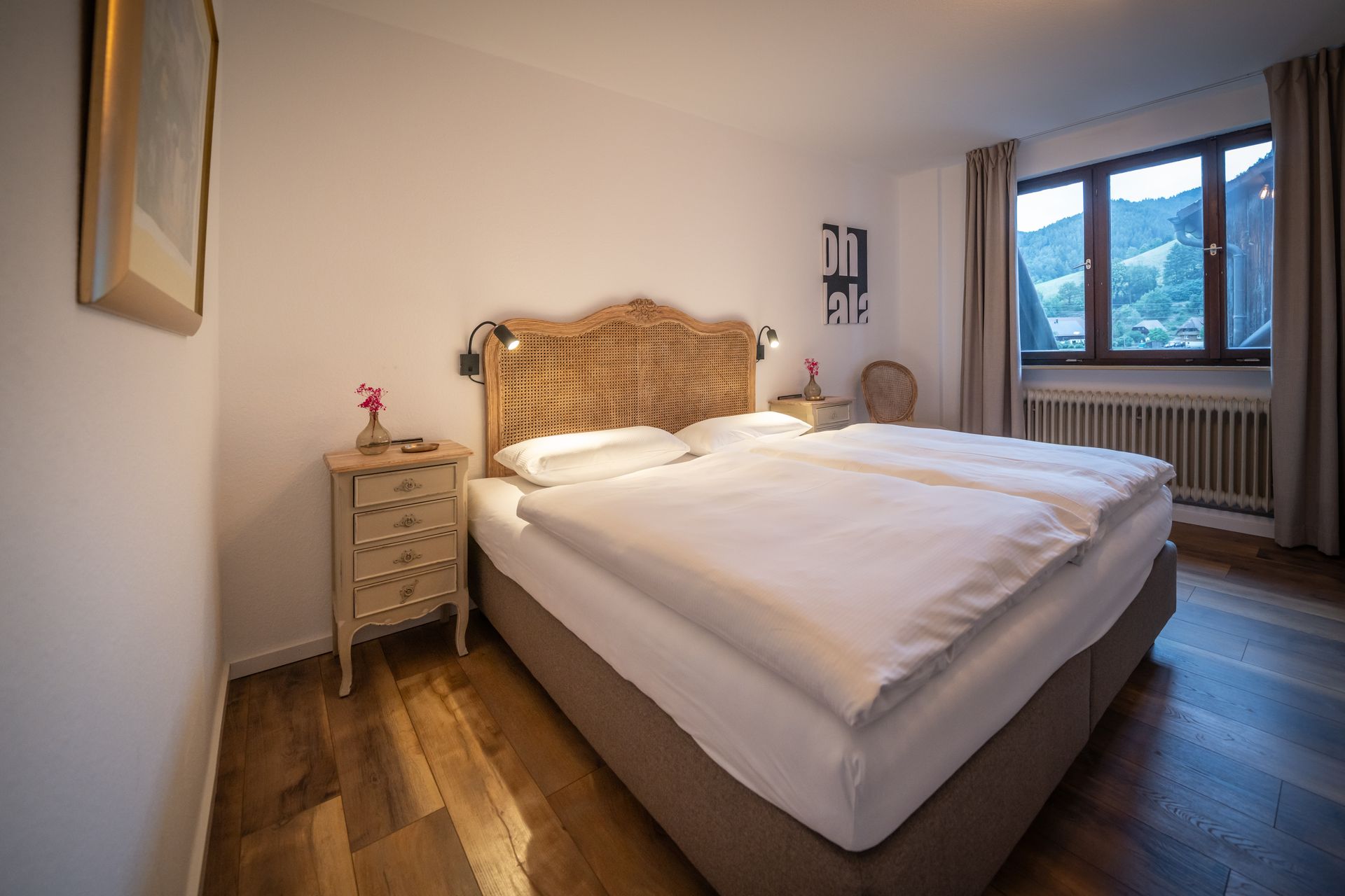 A bedroom with a bed , nightstand , and window.