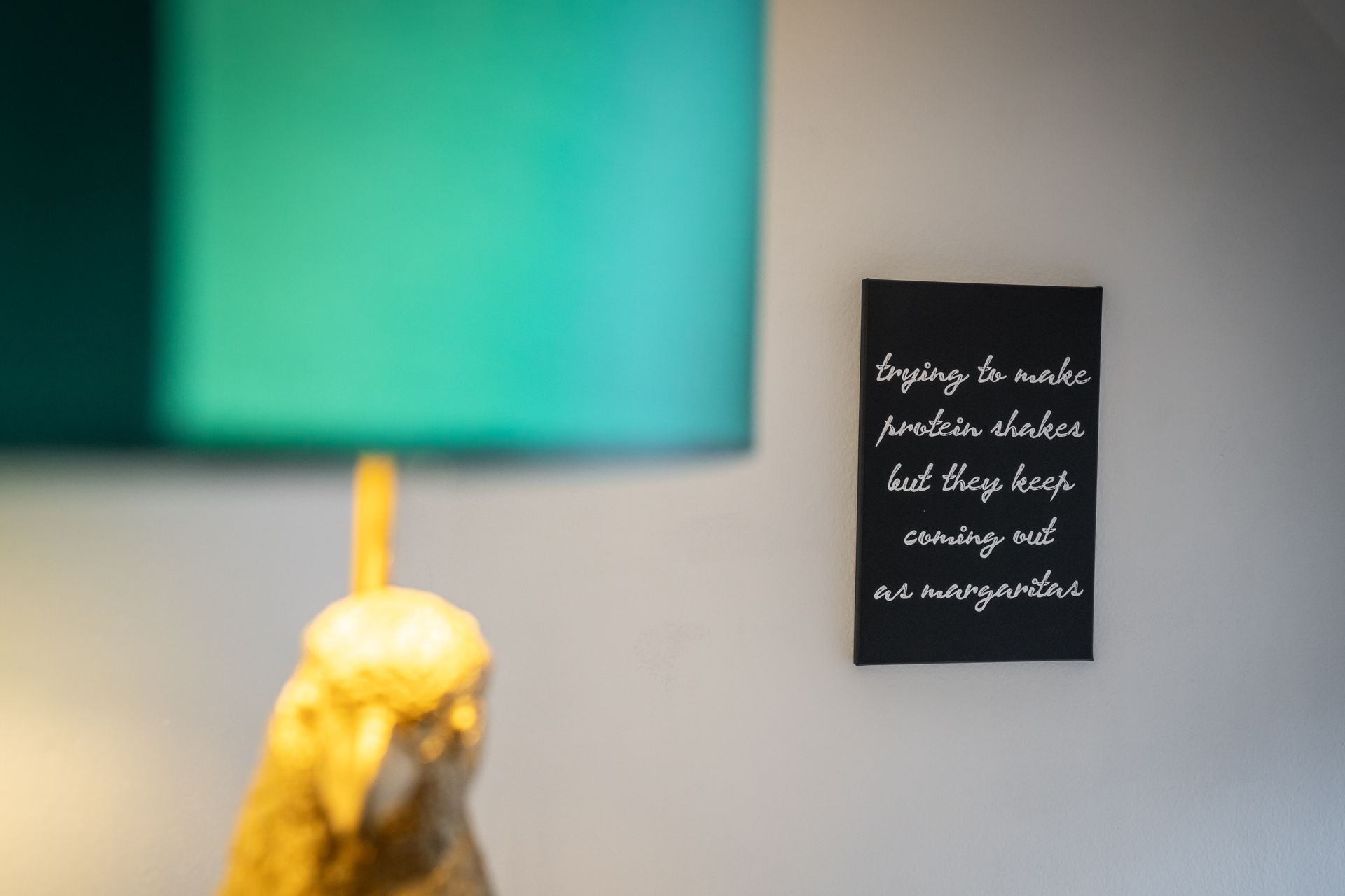 A lamp with a quote on the wall behind it