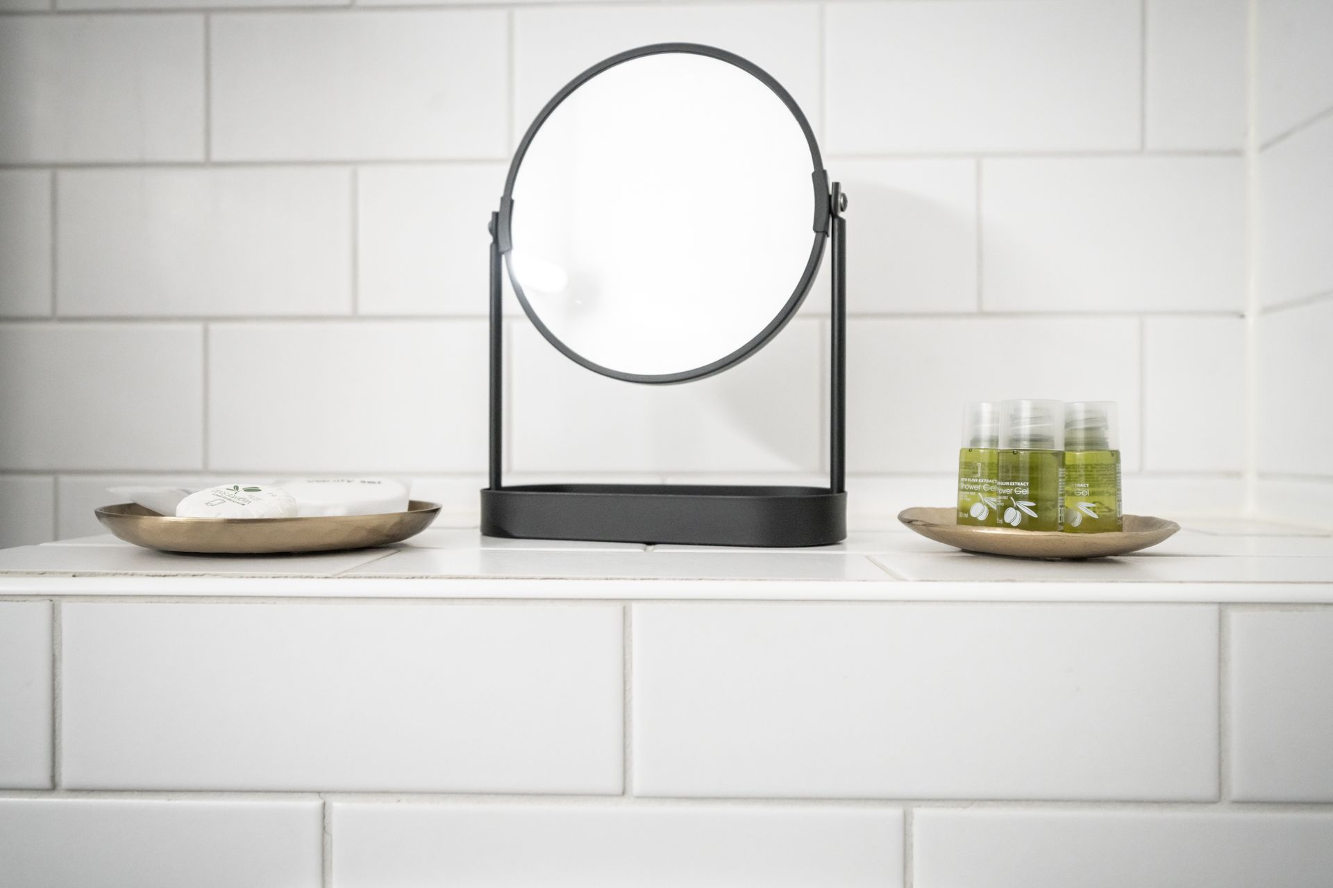 A bathroom with a mirror and bottles of soap on a shelf