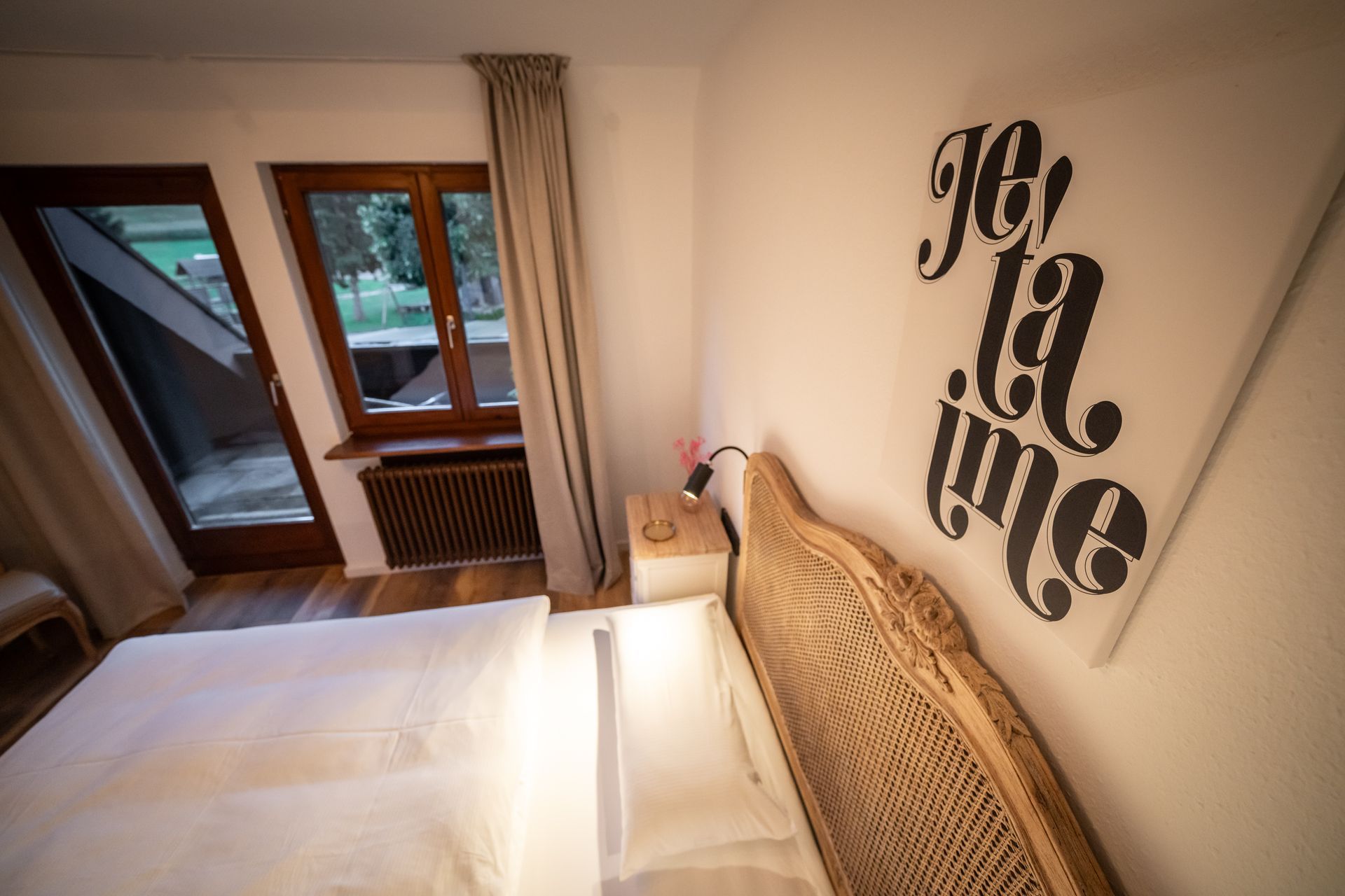 A bedroom with a bed and a sign on the wall that says je t'aime