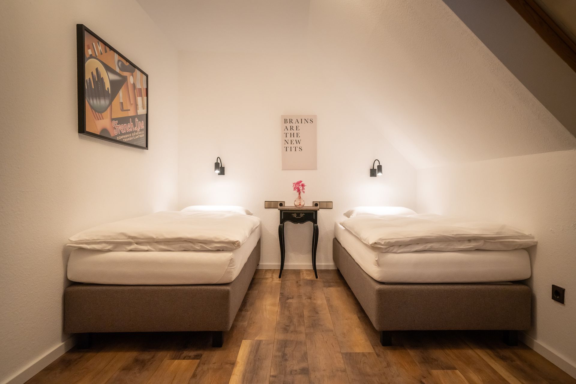 A bedroom with two twin beds and a table.