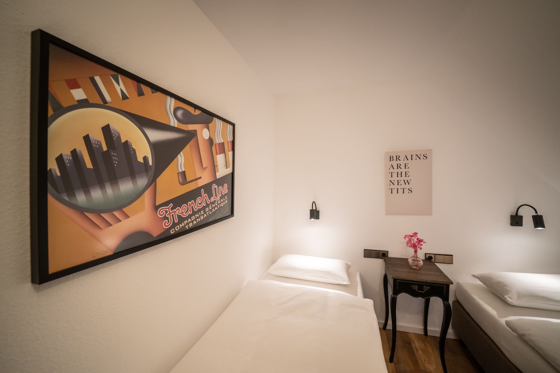 A bedroom with two beds and a painting on the wall.