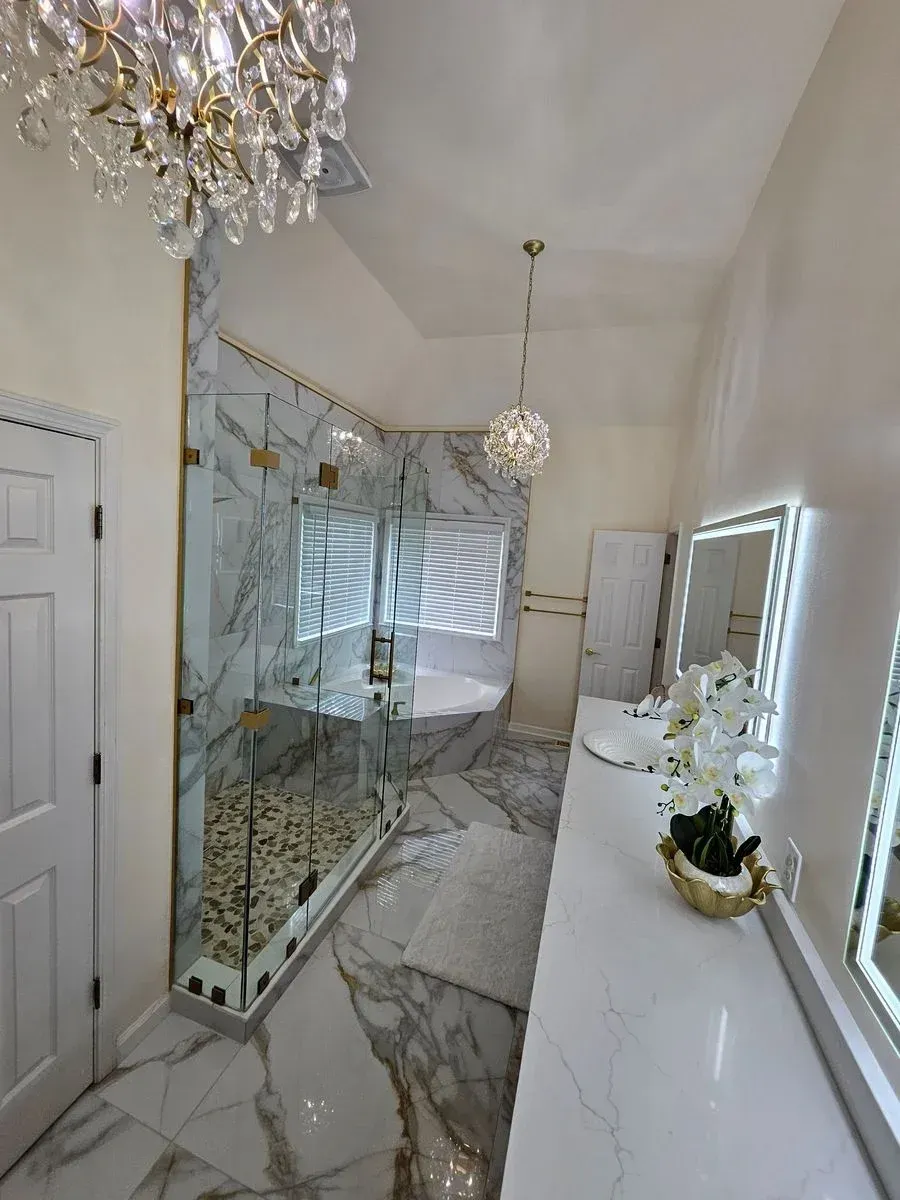 Elegant hallway with mirrored wall, marble floor, chandelier, and white console by windows