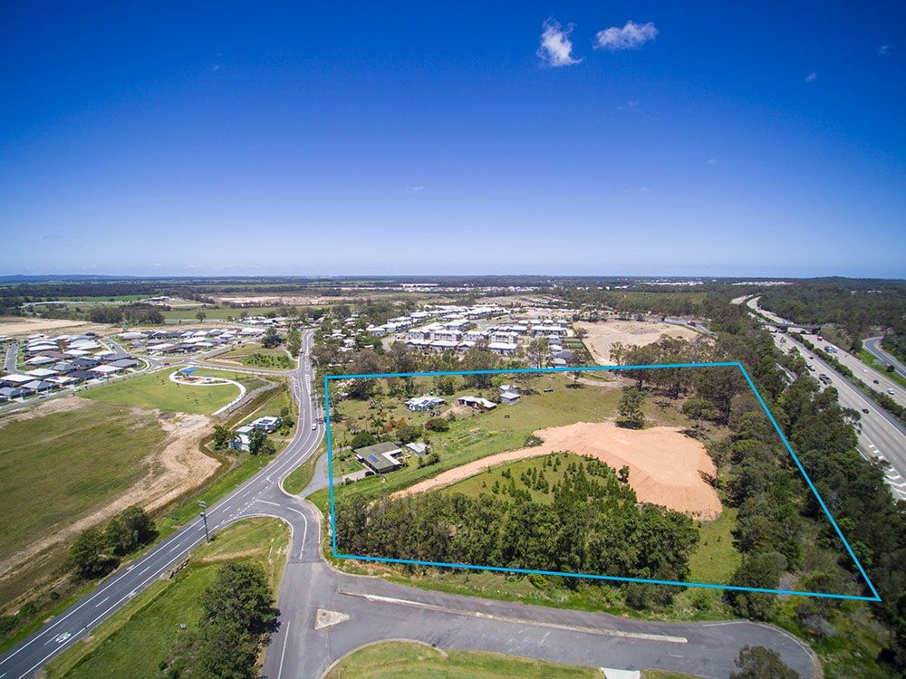 An Aerial View Of A Residential Area Surrounded By Trees And A Road — Harrison Development Group In Surfers Paradise, QLD