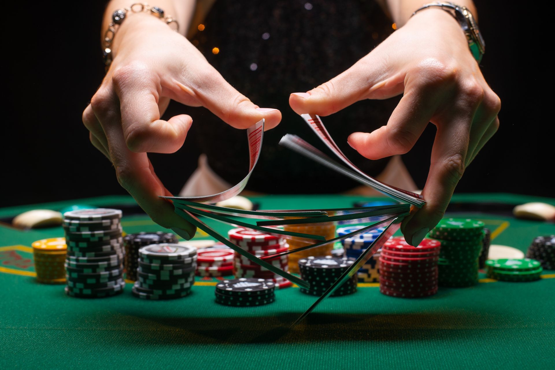 A person is playing poker with chips on a green table.