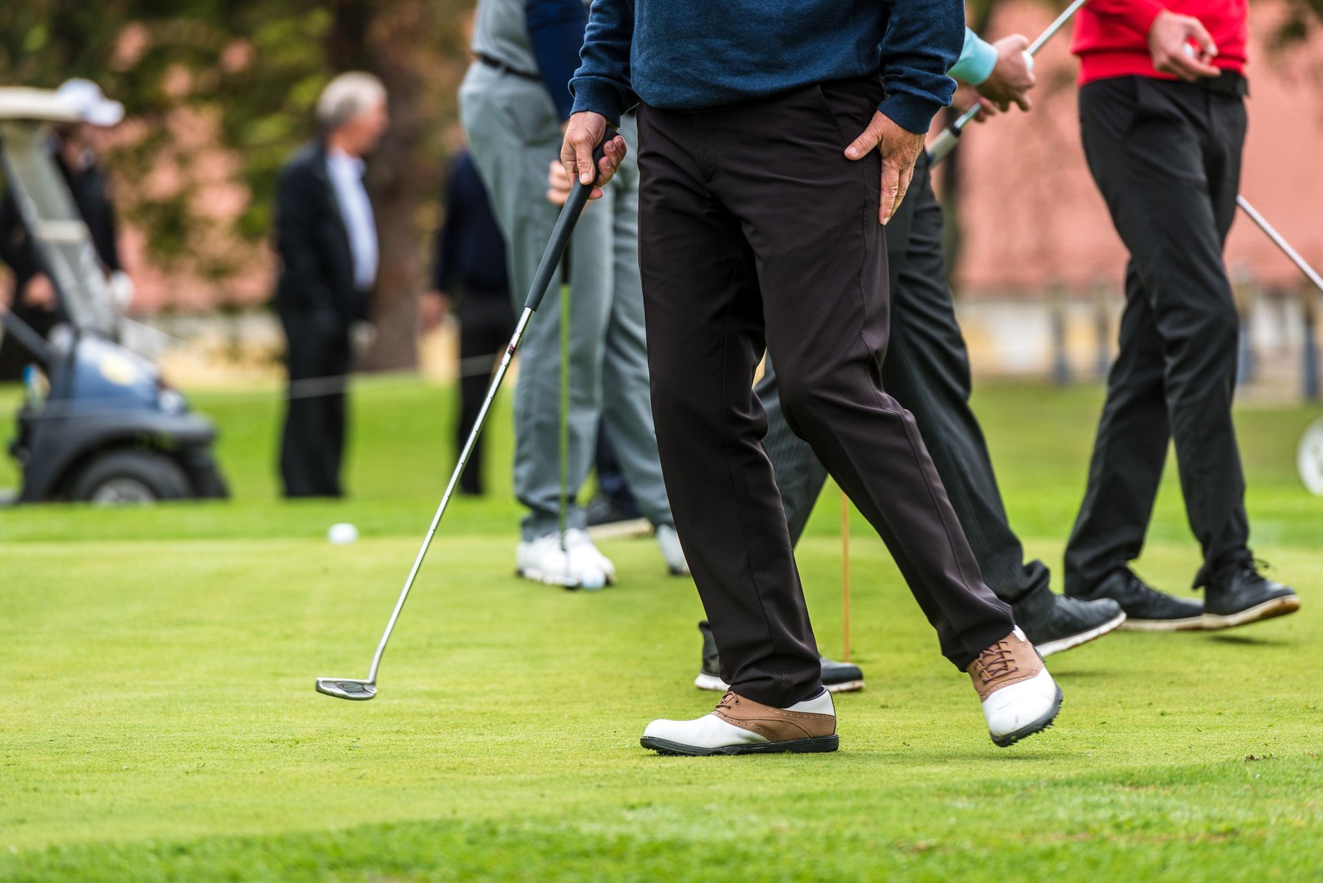 A group of men are playing golf on a golf course.