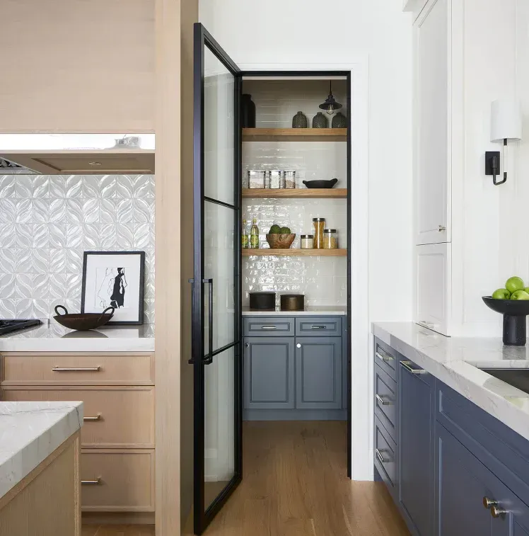 A kitchen with blue cabinets and a walk in pantry