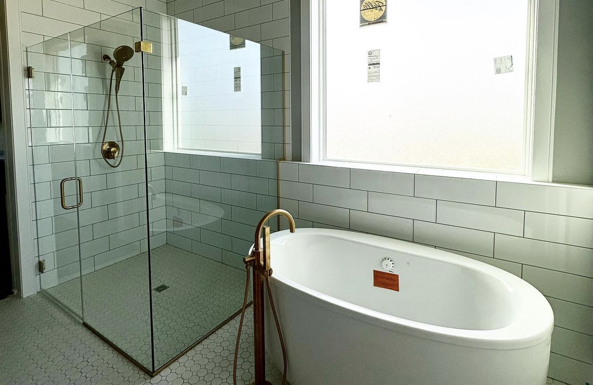 A bathroom with a bathtub and a walk in shower.