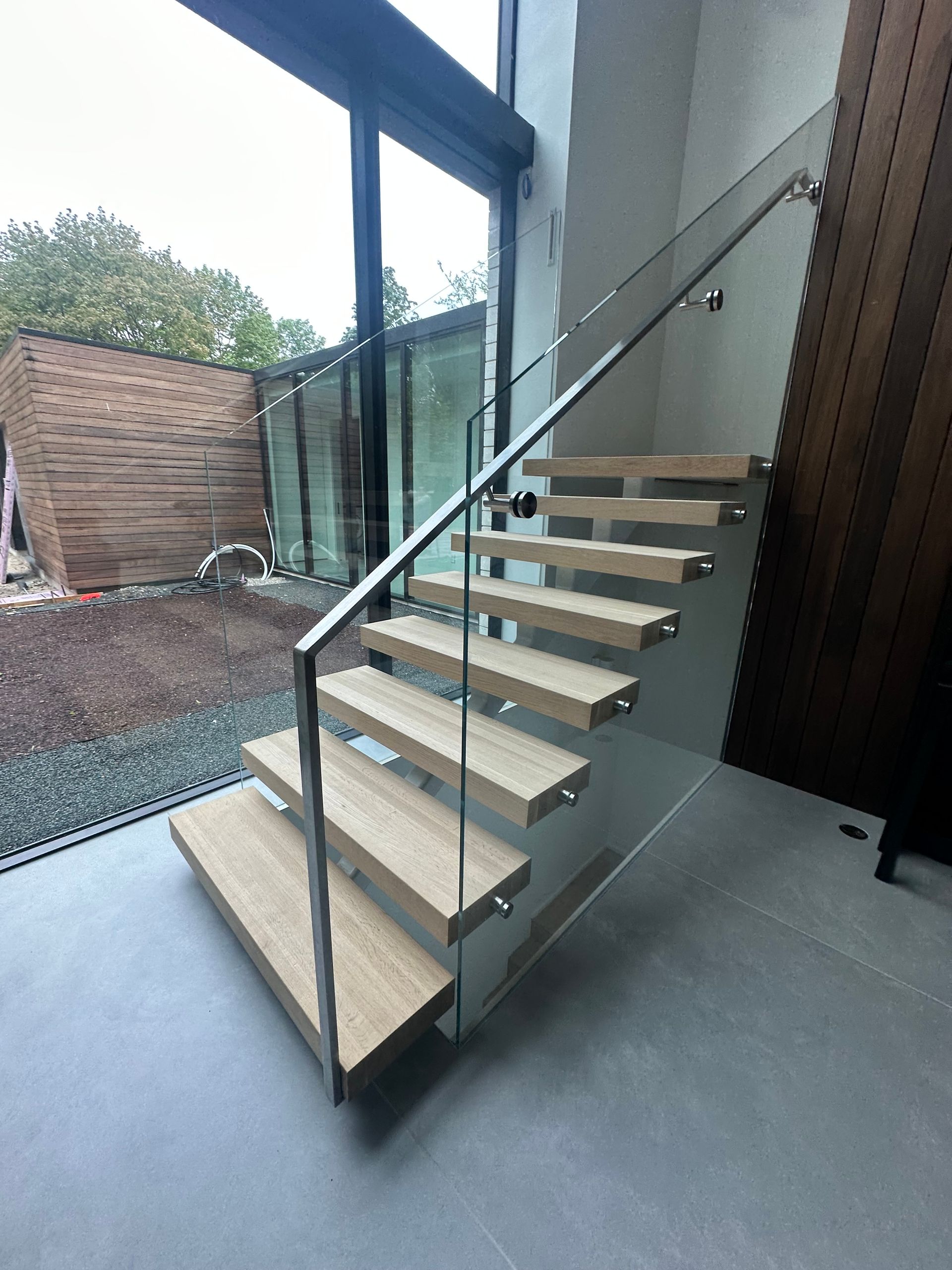 A staircase with wooden steps and a glass railing