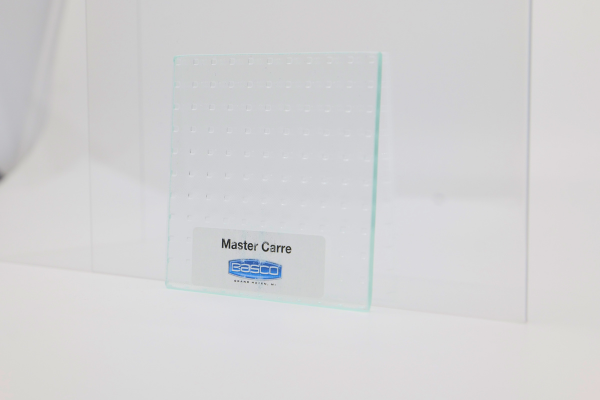 Two glass samples on white surface, one textured, labeled 