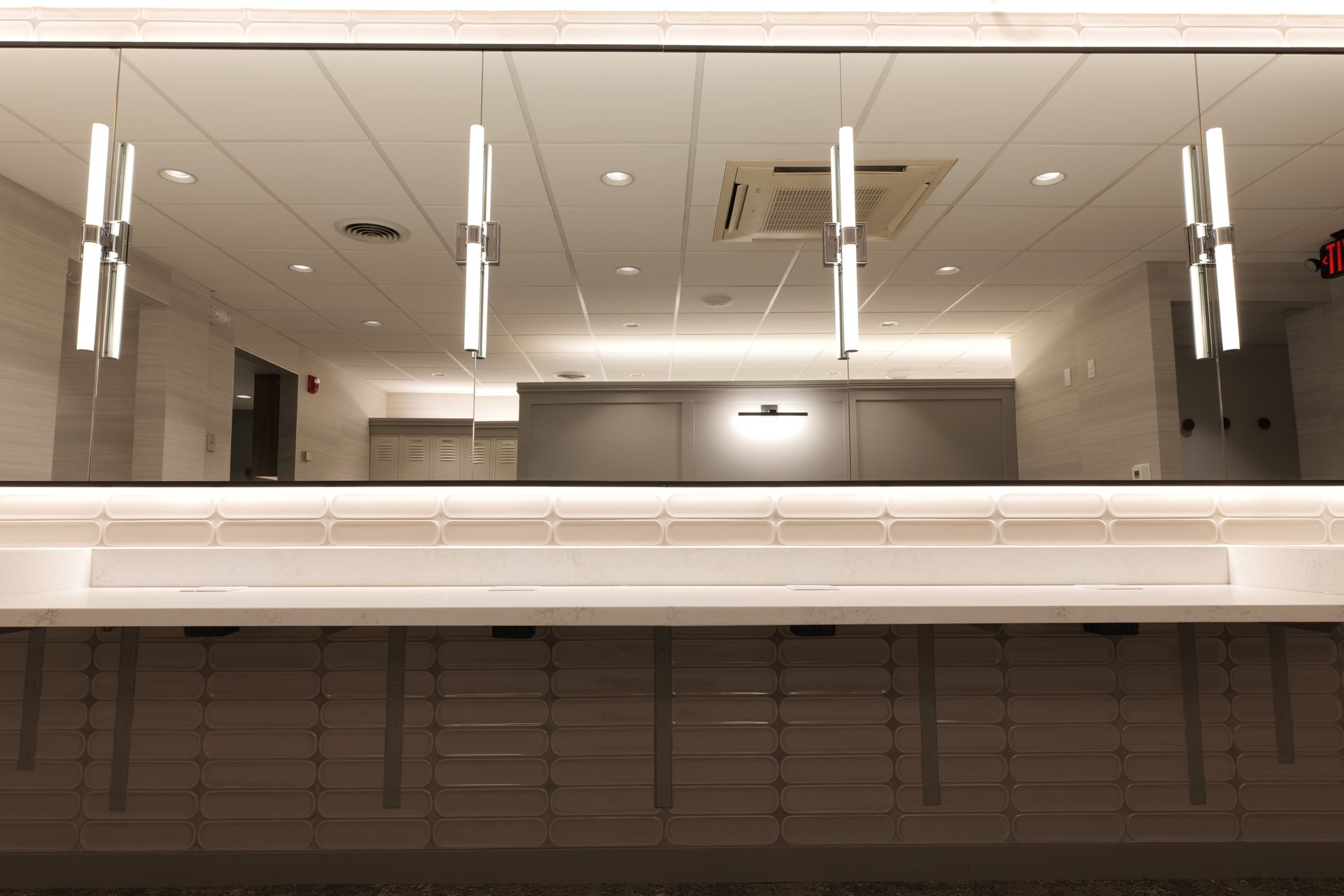 Modern interior with glass divider, overhead lights, and a counter below.