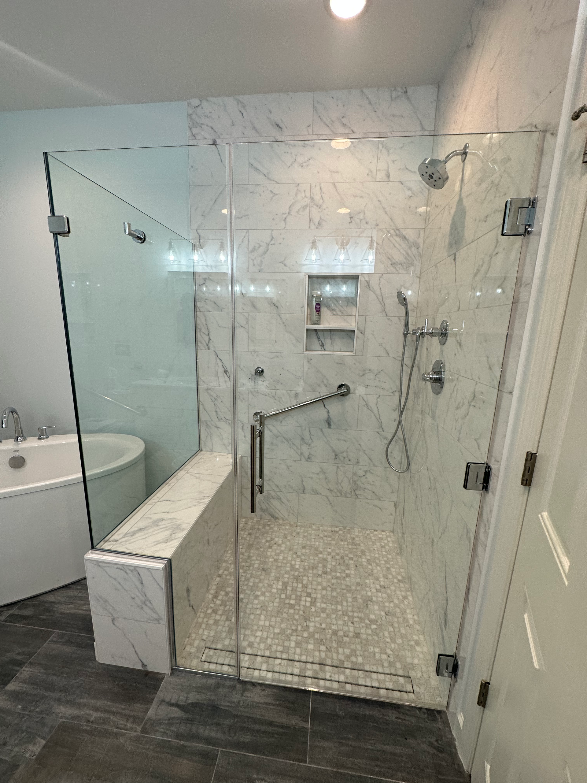 A bathroom with a walk in shower and a bathtub.