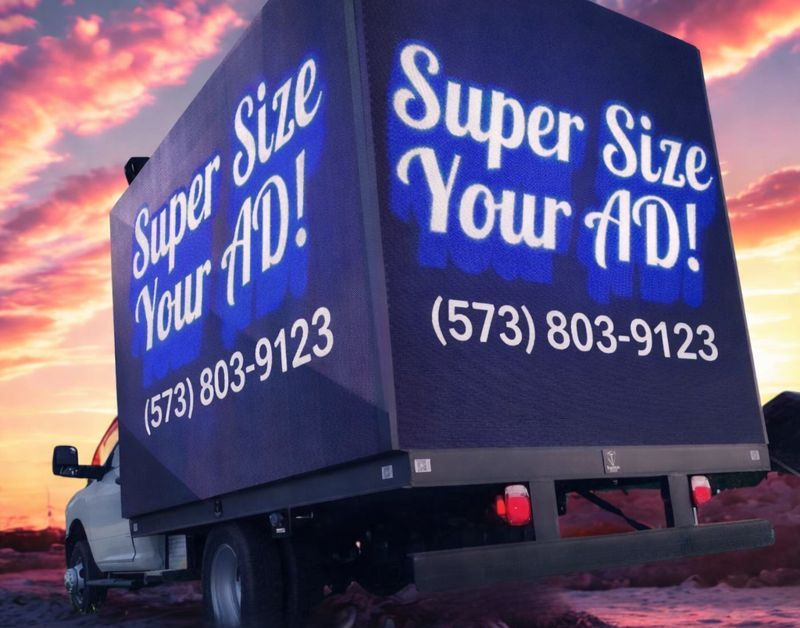 A mobile billboard truck against a sunset, displaying the text "Super Size Your AD!" and the phone number (573) 803-9123.