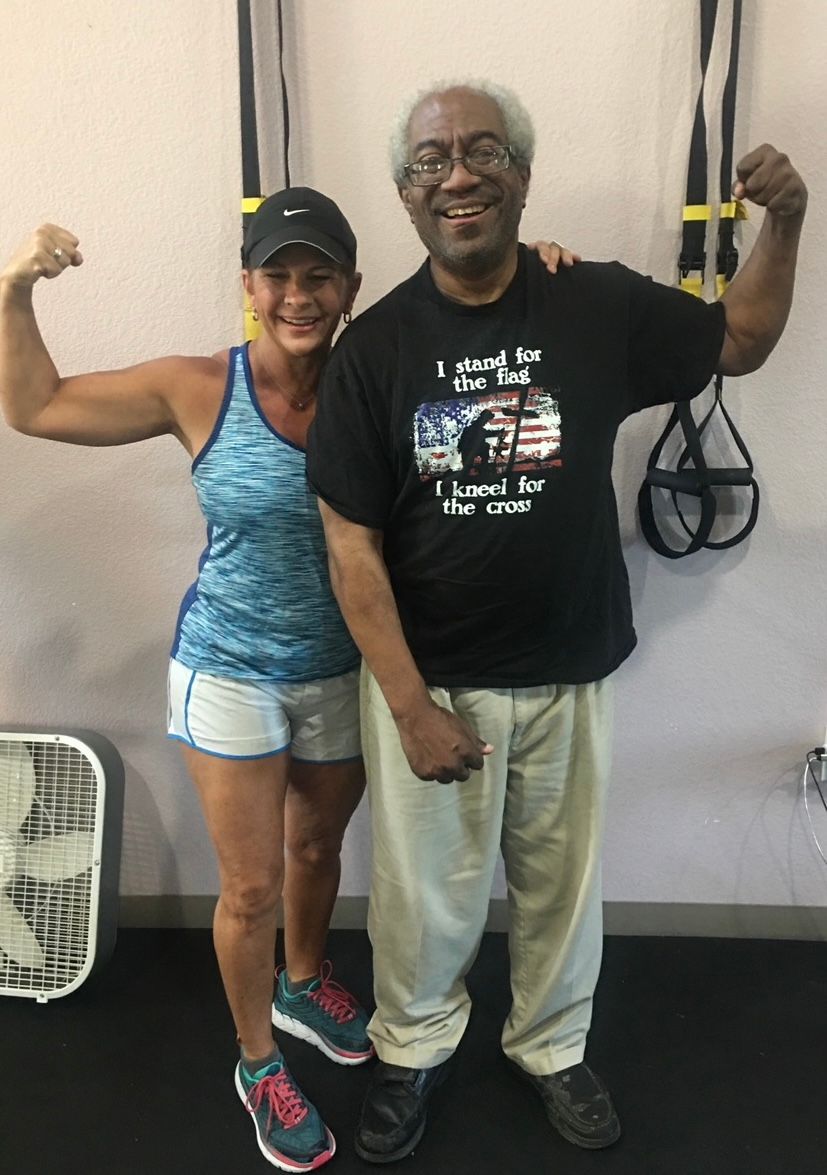 A man and a woman are posing for a picture in a gym.