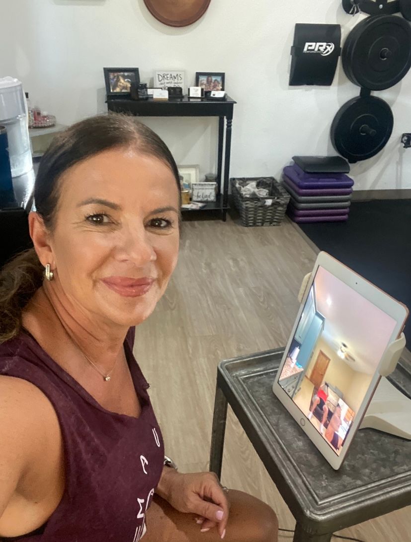 A woman is sitting at a table with a tablet in front of her