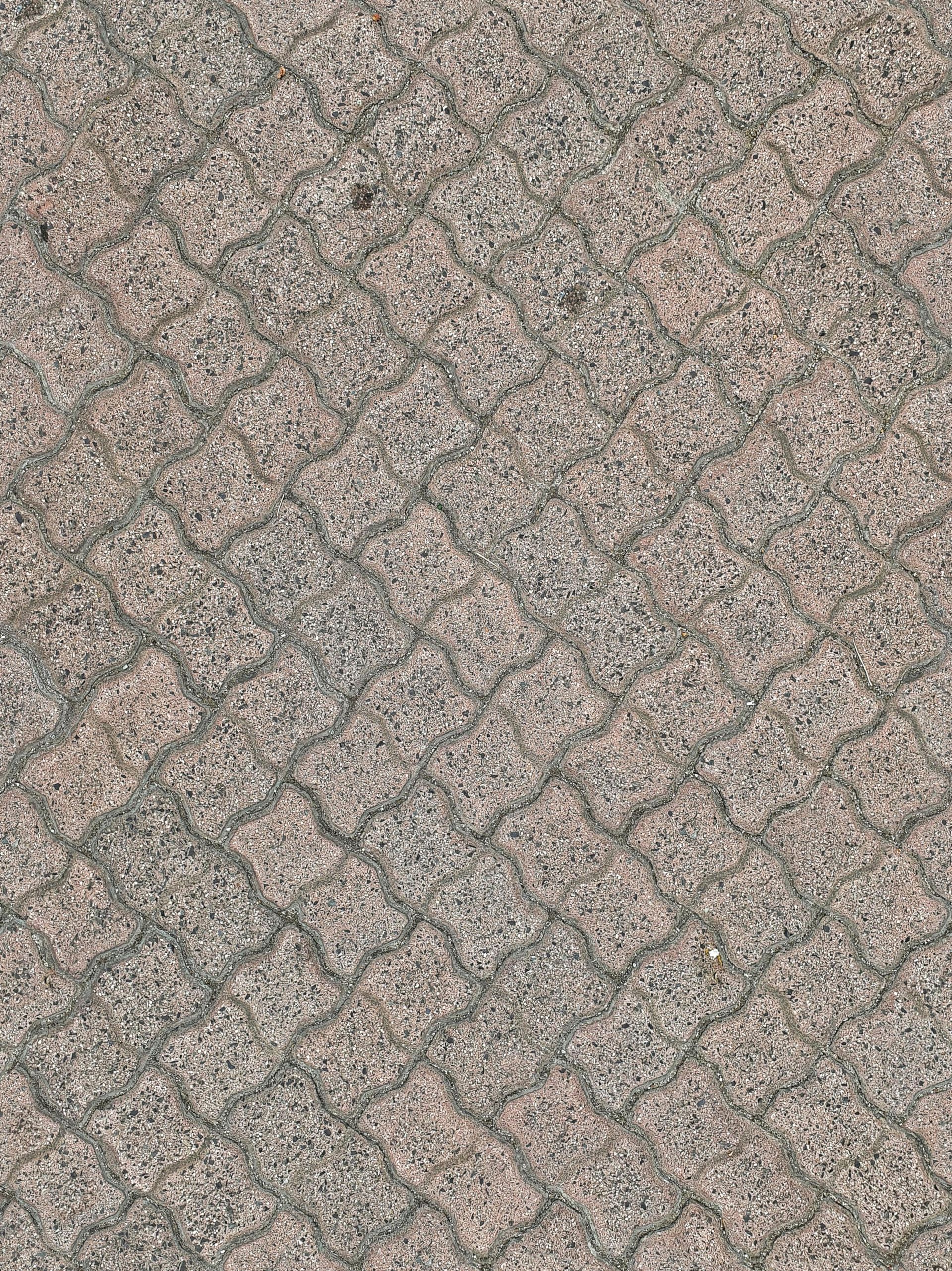 Close-up of gray and beige textured paving stones in a diagonal brick pattern