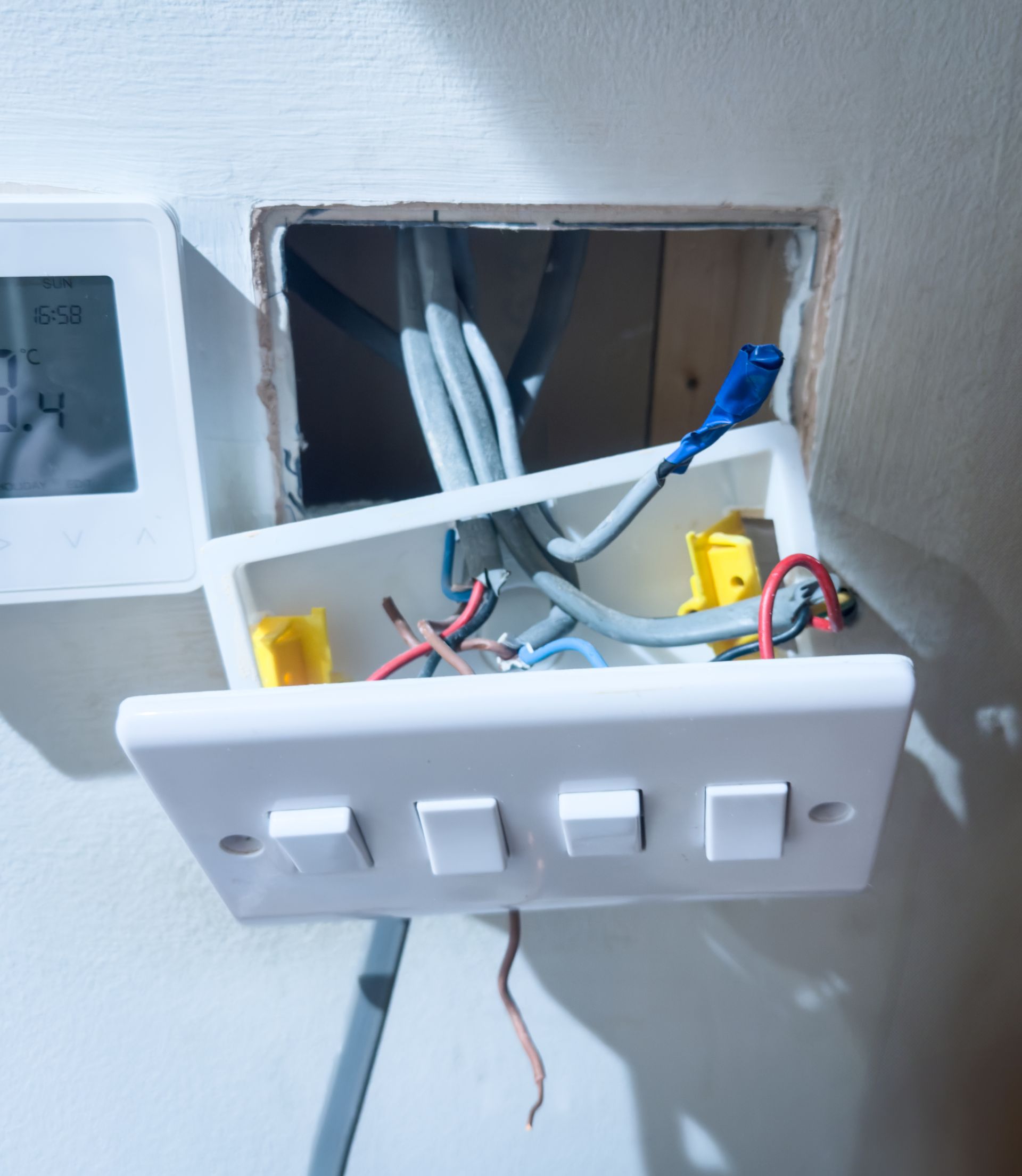 Electrical control panel with white modules, colorful wiring, and terminal blocks in an equipment cabinet