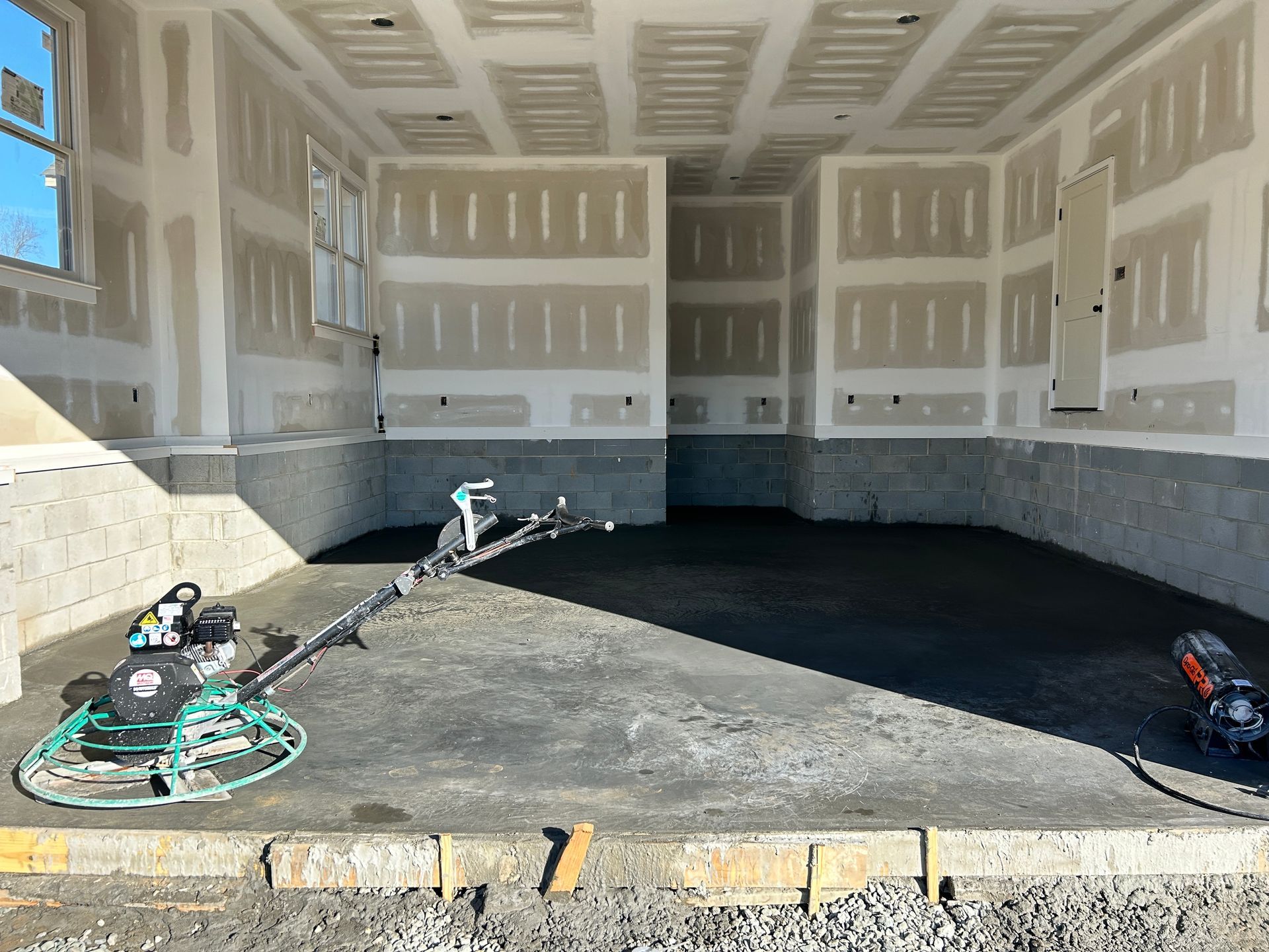 Empty brick-walled room with polished concrete floor and skylights overhead
