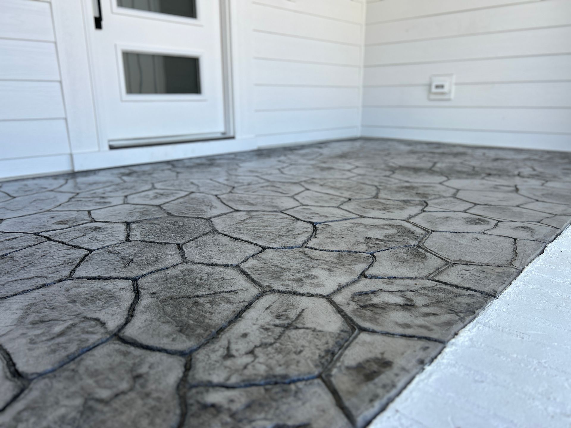 Front porch steps at dusk with slate tile and warm light from a wooden front door