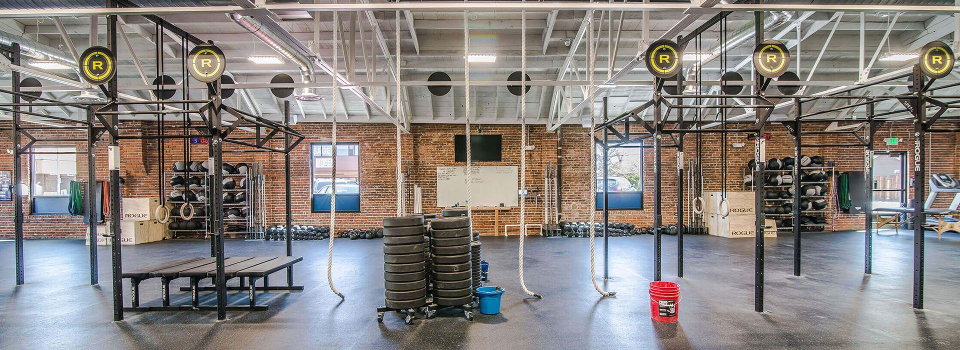 Industrial warehouse with metal shelving, stacked boxes, and a polished concrete floor under bright overhead lights