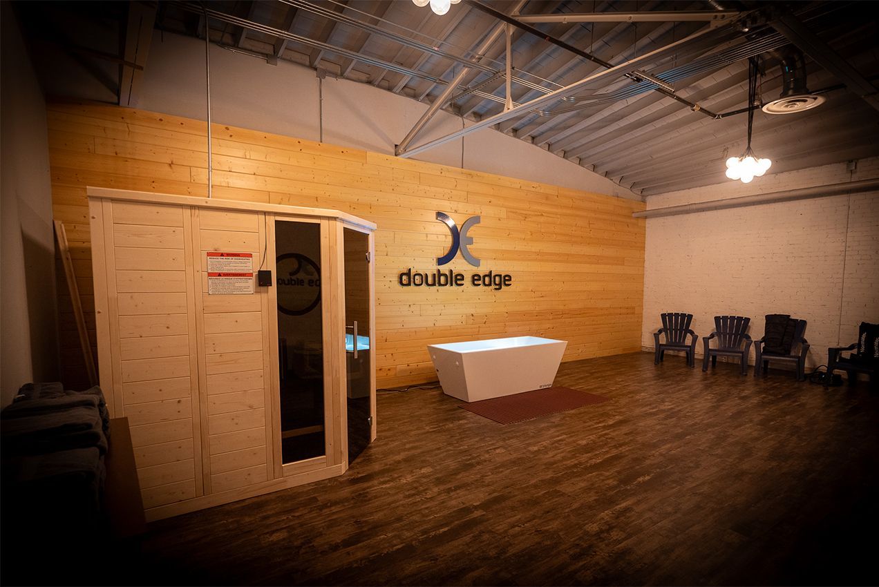Empty rustic event space with wooden walls, high ceiling, reception table, and chairs against the wall